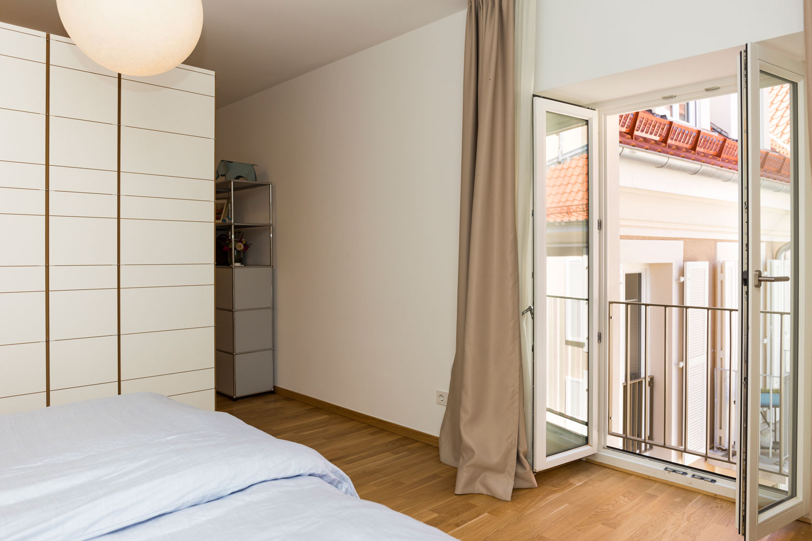 Schlafzimmereinrichtung mit großen Kleiderschrank und Ausblick auf einen schönen Balkon