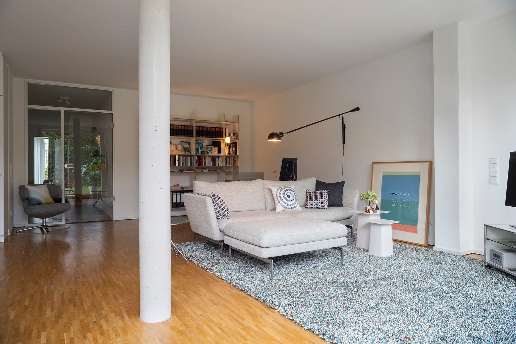 Wohnzimmereinrichtung für eine kleine zwei Zimmer Wohnung mit Raumtrennung und bequemem Sofa