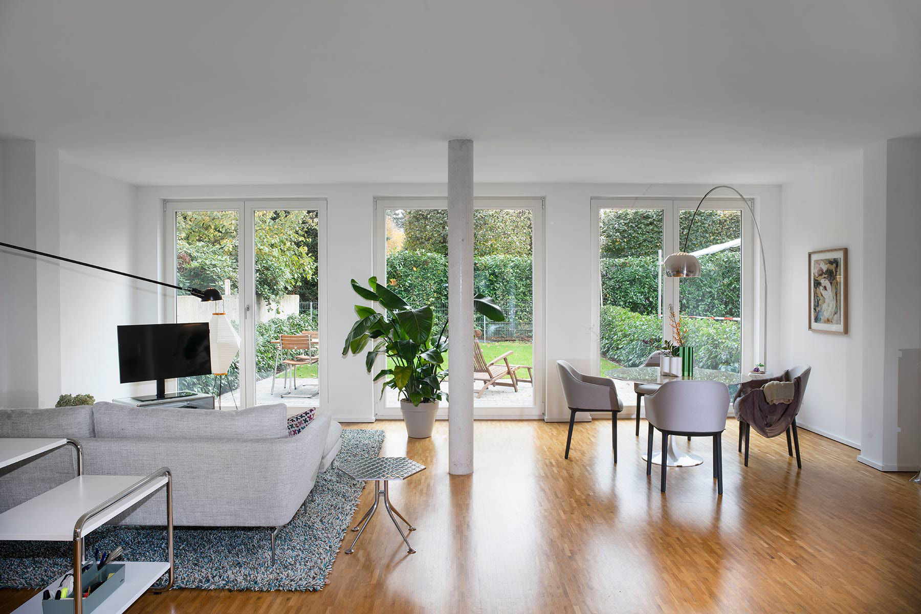 Zwei Zimmerwohnung von Raum und Form eingerichtet mit große Fenstern und raumnutzendem Design