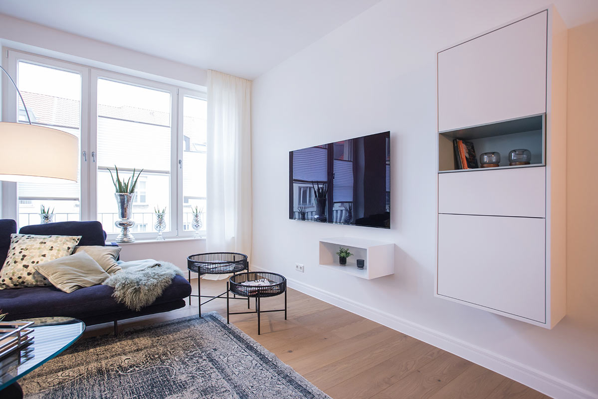 Elegante und zeitlose Wohnzimmereinrichtung mit Wandregalen und kleinen Couchtischen